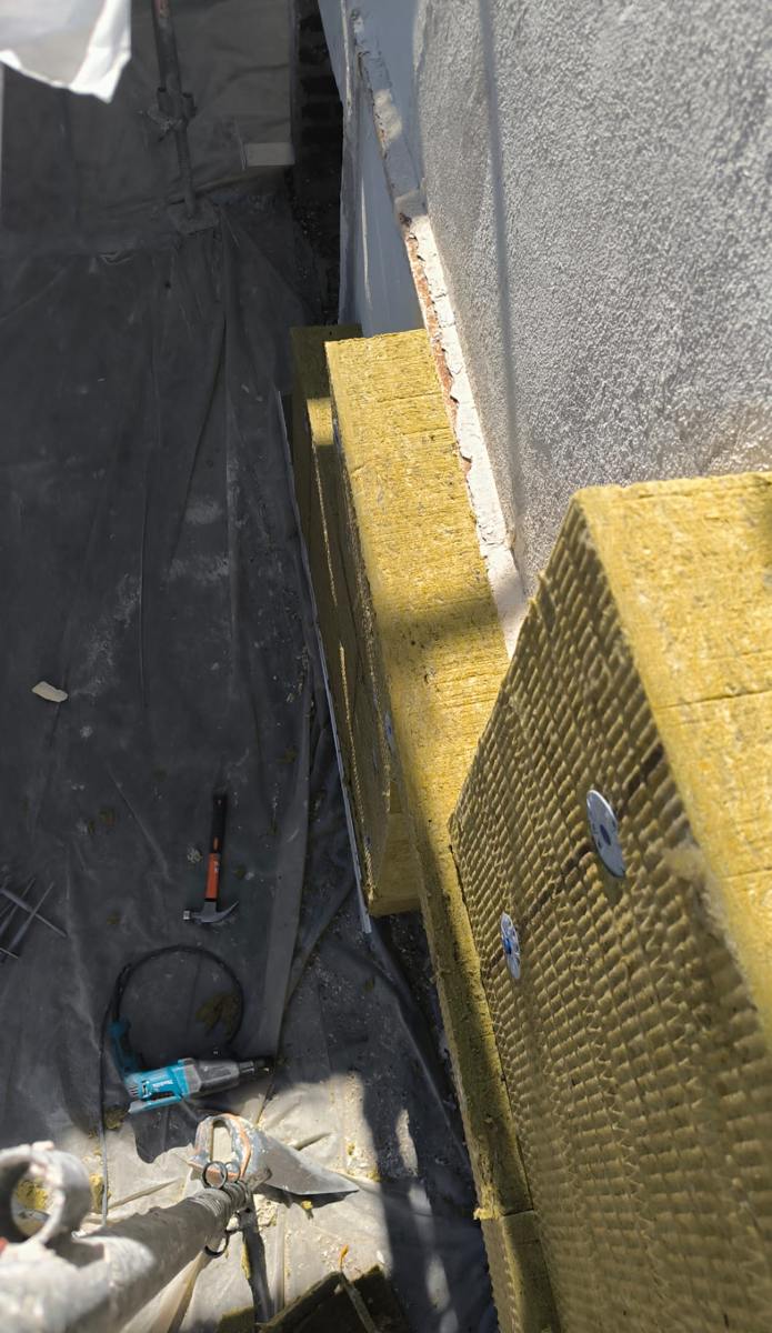 Panneaux de laine de roche et chevilles à rosace sur une façade de pavillon à Goussainville