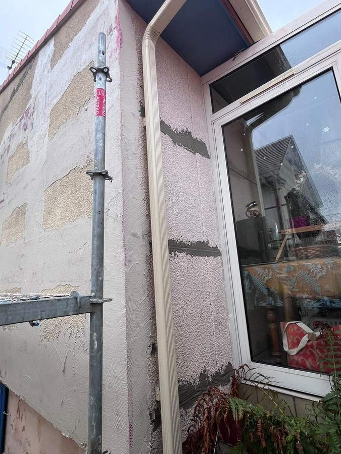 Détail de la reprise des fissures à la truelle près d'une fenêtre, chantier Mira Façade à Villeparisis